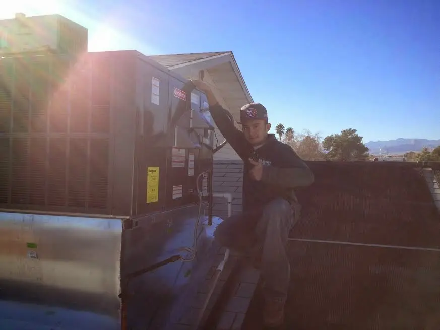 HVAC technician performing AC Tune-Up on a rooftop unit in Plainfield